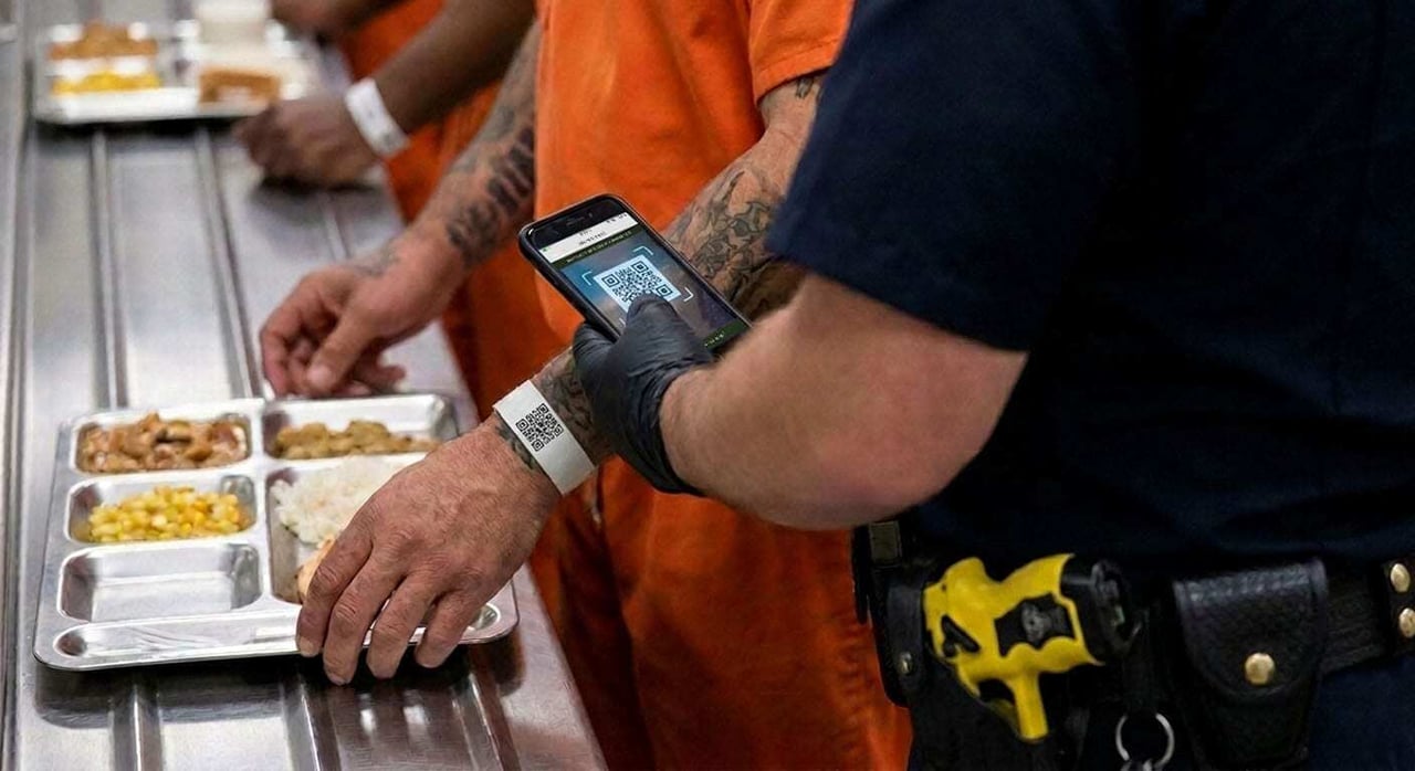 Correctional officer confirming an inmate meal delivery on a handheld device